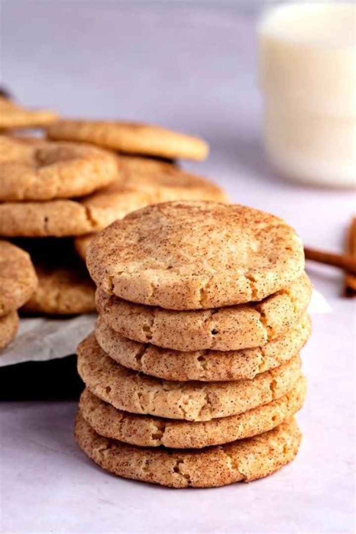 Stack of cinnamon cookies on parchment paper.
